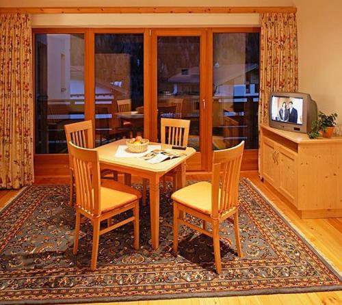 a dining room with a table and chairs and a tv at Apart Ehart in Sankt Anton am Arlberg