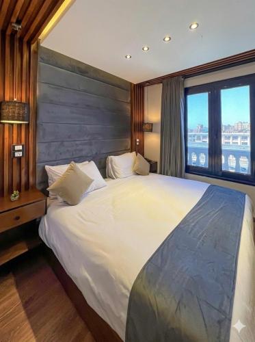 a bedroom with a large bed and a large window at Royal Plaza Pyramids View in Cairo