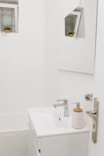 a white bathroom with a sink and a mirror at Encanto do Lima Guest House By Lethes Legacy in Ponte de Lima