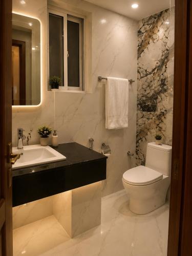 a white bathroom with a sink and a toilet at Emerald Villa Islamabad in Islamabad