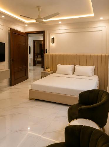 a bedroom with a large bed and a chair at Emerald Villa Islamabad in Islamabad