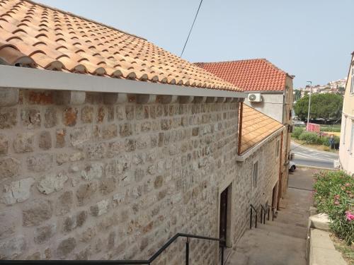 an old stone wall with graffiti on the side of a building at Apartment Mia in Dubrovnik