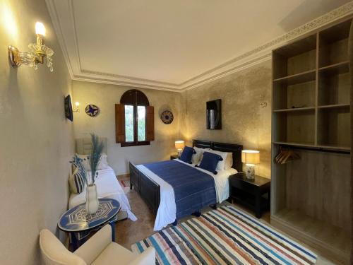 a bedroom with a blue bed and a couch at Villa Bouchra in Marrakesh