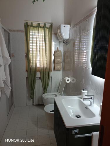 a bathroom with a white toilet and a sink at Vacanze da Paola in Campomarino