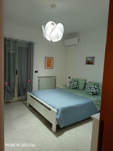 a bedroom with a blue bed and a chandelier at Vacanze da Paola in Campomarino