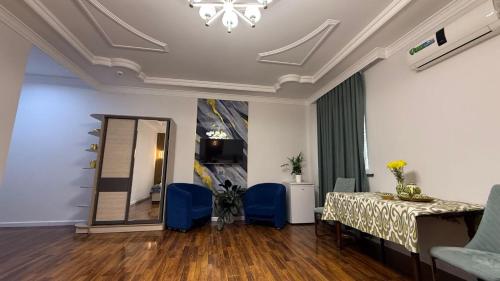 a room with a table and blue chairs and a mirror at Giza Grand Hotel in Tashkent