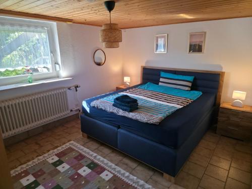 a bedroom with a blue bed and a window at House of Haiger Ferienwohnung mit Charme in Haiger