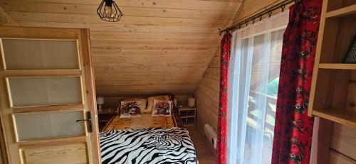 a small room with a bed and a window at Chatki U Hanusi in Czchów