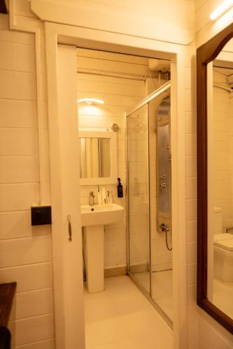 a bathroom with a shower and a sink and a mirror at Royal Bishnu in Calangute