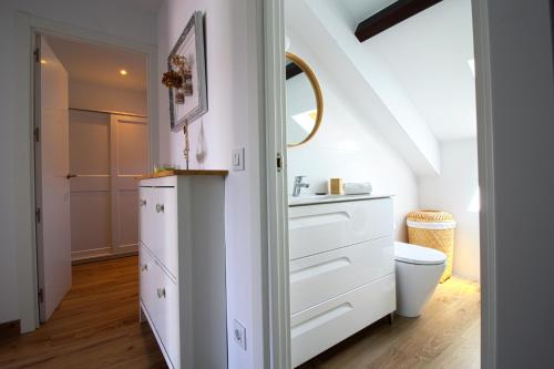 a white bathroom with a sink and a toilet at Apartamento Arena Dorada in Somo
