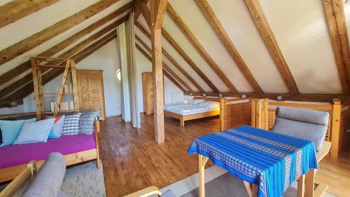a attic room with a bed and a table at Helles Landhaus auf Waldlichtung in Dießen am Ammersee