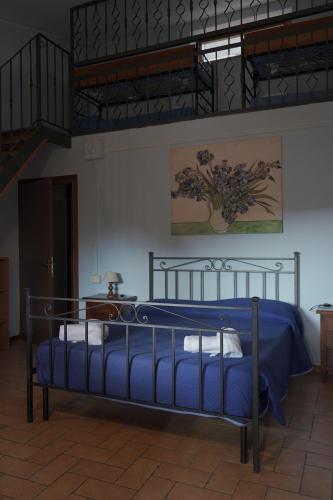 a bedroom with a bed with a blue comforter at La dimora degli Etruschi in Civitella Cesi