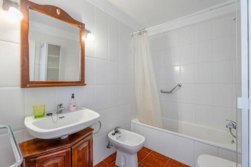 a bathroom with a sink and a toilet and a mirror at Casa Perla in Playa de Santiago
