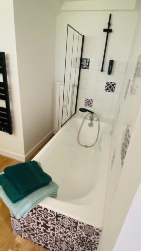 a bathroom with a bath tub with a cross on the wall at Studio Saint Julien de Concelles 5 minutes de la Loire in Saint-Julien-de-Concelles