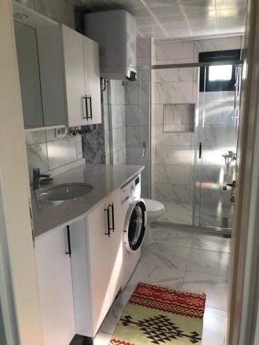 a bathroom with a sink and a washing machine at Muğladaki Eviniz in Muğla