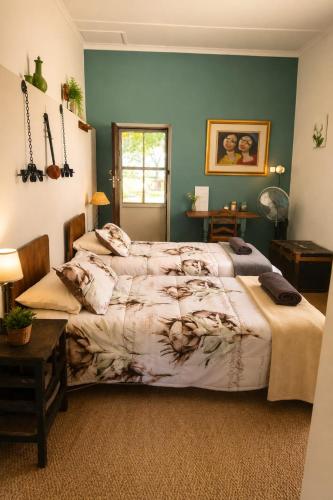 a bedroom with a bed and a green wall at The Big Tree Cottage in Graafwater
