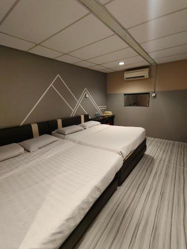 a bedroom with two beds in a room at Sea Lion Pulau Ketam Inn in Bagan Teochew