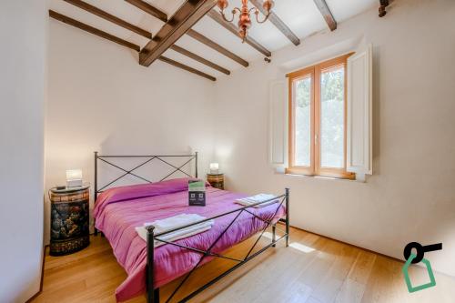 a bedroom with a bed with pink sheets and a window at Hotiday Grosseto Podere in Grosseto