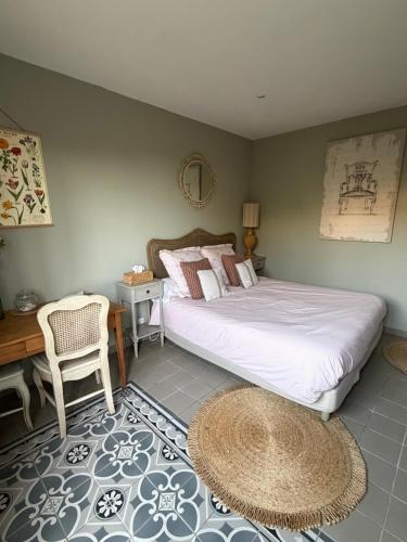 a bedroom with a bed and a desk and a chair at Céline et Olivier in Pornic
