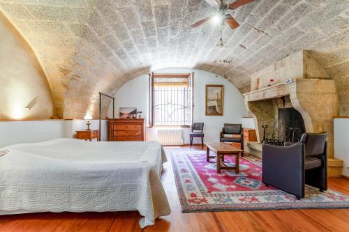 a bedroom with a bed and a fireplace at Au Fil Des 5 Saisons in Vers Pont du Gard