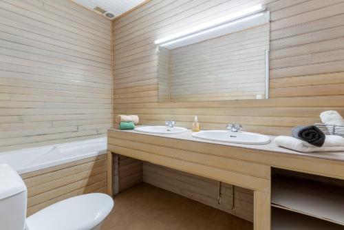 a bathroom with two sinks and a tub and a toilet at Le Mas Perdu Gîte Studio Parme in Saint-Christol-lès-Alès