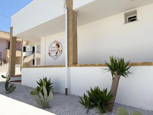 a white building with plants in front of it at Donna Ginevra Rooms - A soli 300m dalla Spiaggia in Lido Marini
