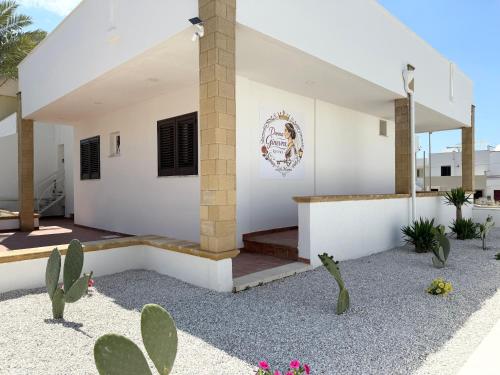 a white house with cactuses in front of it at Donna Ginevra Rooms - A soli 300m dalla Spiaggia in Lido Marini