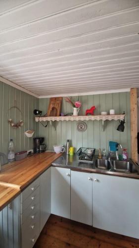 a kitchen with white cabinets and a wooden counter top at Typisches Schwedisches Haus in Eriksmåla