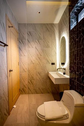 a bathroom with a toilet and a sink at Triple P พูลวิลล่า ชะอำ in Ban Bo Prakhon
