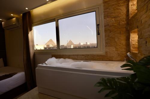 a bath tub in a room with a window at Royal Plaza Pyramids View in Cairo