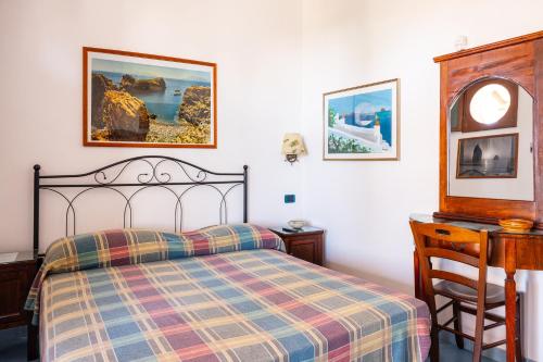 a bedroom with a bed and a desk with a chair at Villa Artemis by Isula in Lipari
