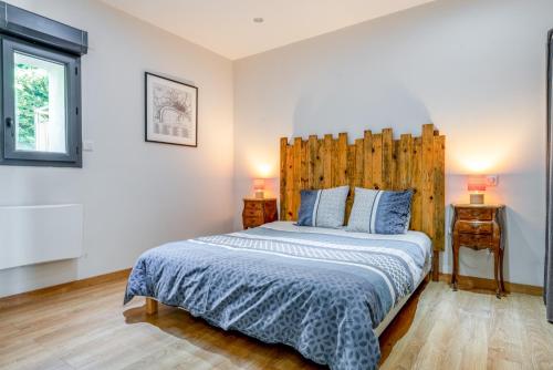 a bedroom with a large bed with a wooden headboard at Mas Delorme 1 in Arles