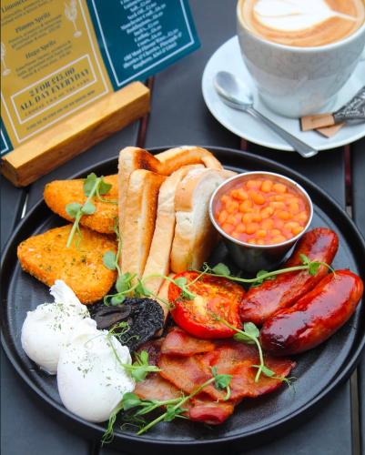 a plate of breakfast food with a cup of coffee at Mitre Hotel Manchester City Centre in Manchester