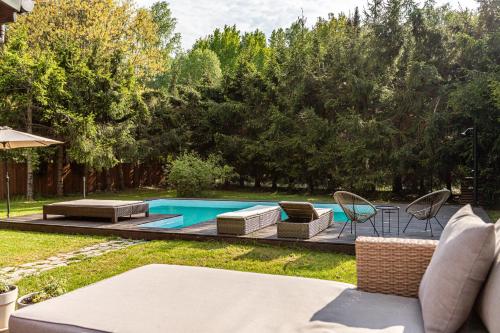 a backyard with a swimming pool with chairs and a table at Leśny Raj in Świętajno