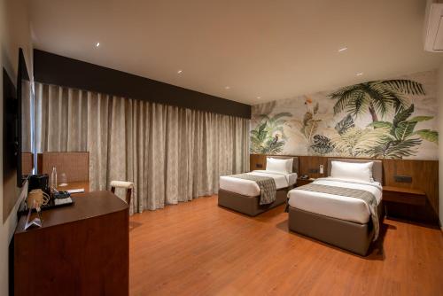 a hotel room with two beds and a desk at Tree of Life Ganga Dwar, Haridwar in Haridwār