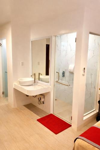 a white bathroom with a sink and a shower at Mayumi Lodge in Puerto Princesa City