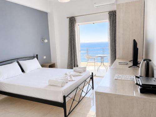 a bedroom with a bed and a view of the ocean at Palasa View in Dhërmi
