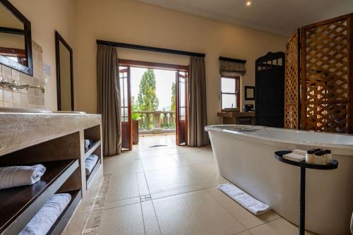 a large bathroom with a tub and a sink at IL Castello Boutique Hotel in Clarens