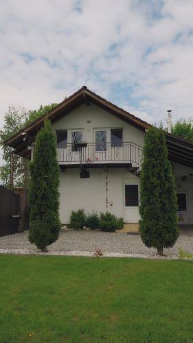 a white house with a balcony and two trees at Cabana Diana in Avrig