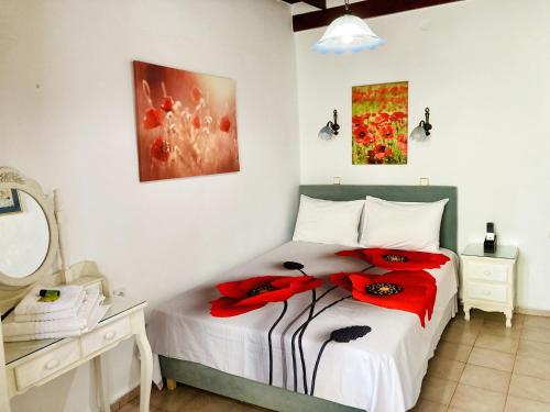 a bedroom with a bed with a red flower on it at Anemones Rooms in Chania