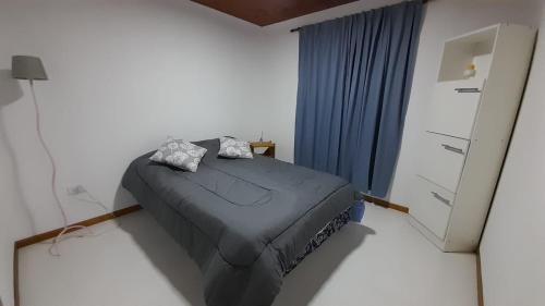 a bedroom with a bed and a dresser at Cabañas La Estación in Chascomús