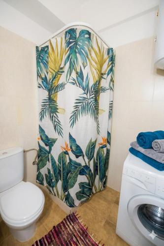 ein Badezimmer mit Toilette und einer Tapete mit Palmen in der Unterkunft Elias Appartment in Volos