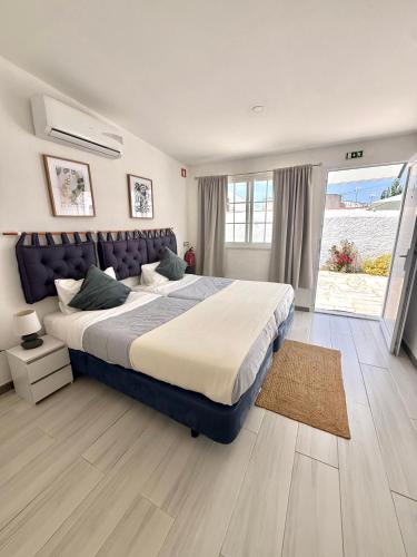 a bedroom with a large bed and a large window at Casa da Calma - GUESTHOUSE in Alandroal
