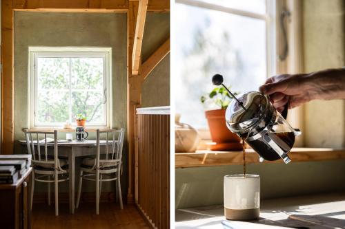 a person pouring a drink into a coffee pot in a kitchen at Allsta Gård in Bjärtrå