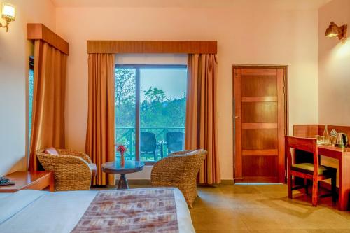 a bedroom with a bed and a desk and a window at The Corbett Greens- A Wild Resort Muhaan in Tota Ām