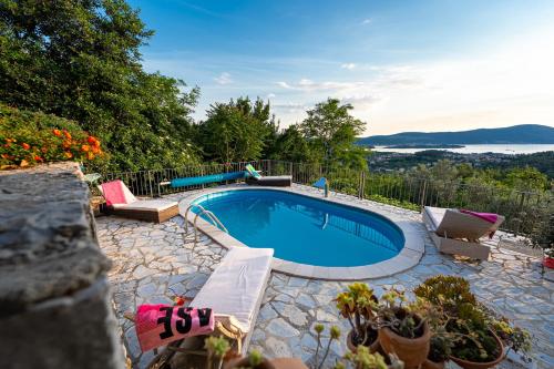 a swimming pool in a yard with chairs and plants at Sunset Holiday Home in Tivat