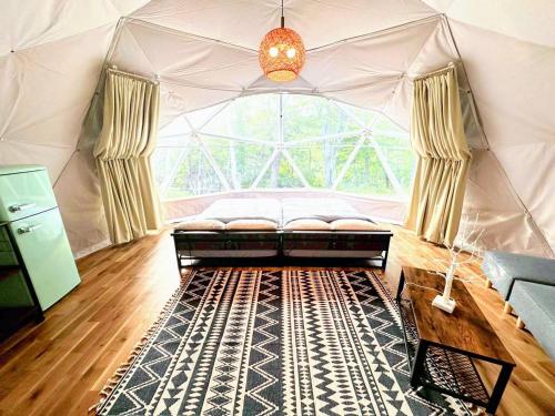 a large room with a couch in a tent at Hotel Asobuba白老 in Shiraoi
