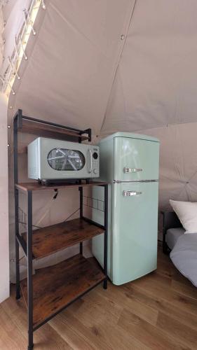 a refrigerator and a microwave on a shelf in a tent at Hotel Asobuba白老 in Shiraoi
