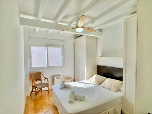 a white bedroom with a bed and a ceiling fan at Spanish Connection - Las Amoladeras in Cabo de Palos