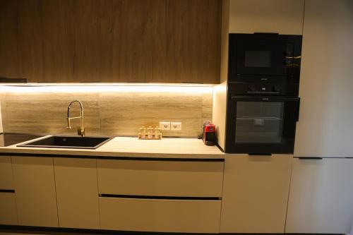 a kitchen with a sink and a microwave at Blue Coast Villa -Perla Resort in Lalëz